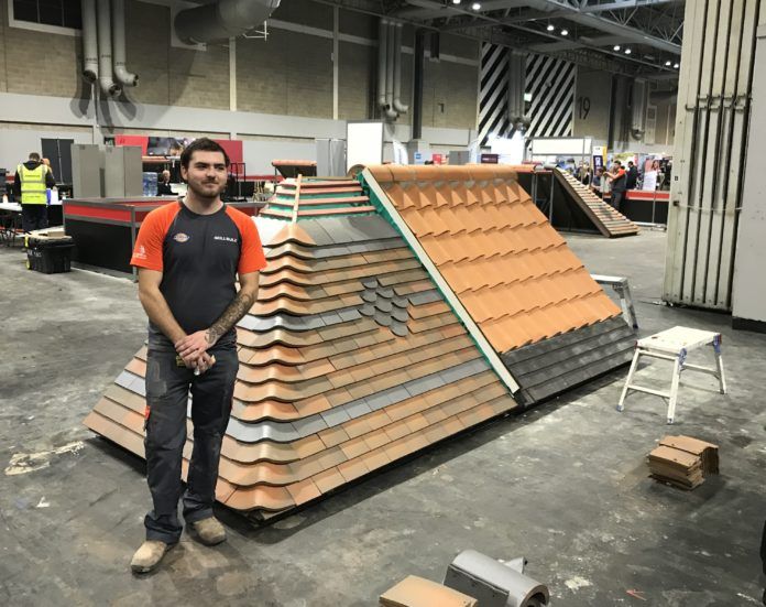 Joe Osborne, winner of the silver medal in Roof Slating & Tiling, next to his competition work