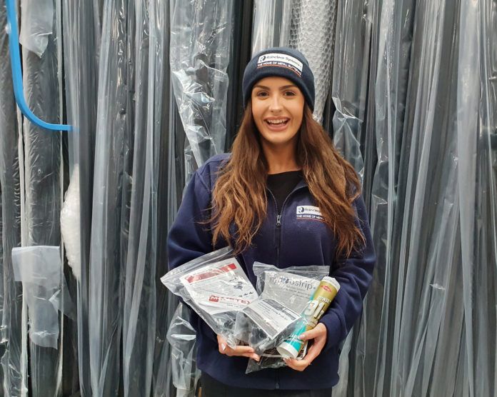 Rainclear’s sales support administrator, Freya Cottell, wearing the winter hat and fleece, and holding an example of fittings customers can expect to receive for free with orders placed in January
